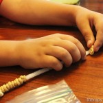 Stringing cheerios onto pipe cleaners